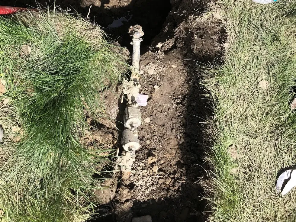Excavated sewer lateral in a Nampa yard showing the old pipe before replacement